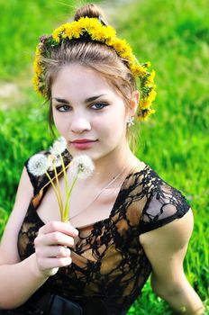 girl with dandelions on her head and in her hand