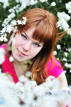  beautiful redheaded girl standing in the treeblossom
