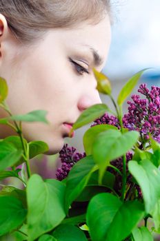  Beautiful teen girl smelling lilac blossoms - close up
