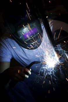 Welder working on the metal fork of a motorcycle