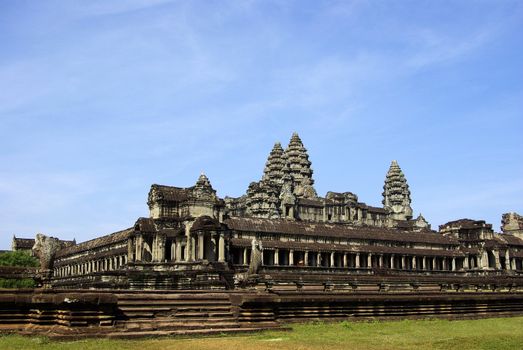 It's a wide corner view of Angkor Wat temple with a blue sky