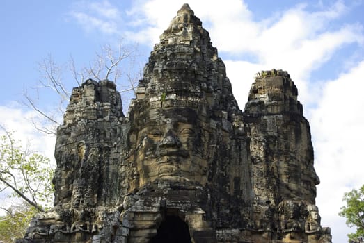 A view below of three towers of Bayon Temple at Angkor where you can see faces of stone