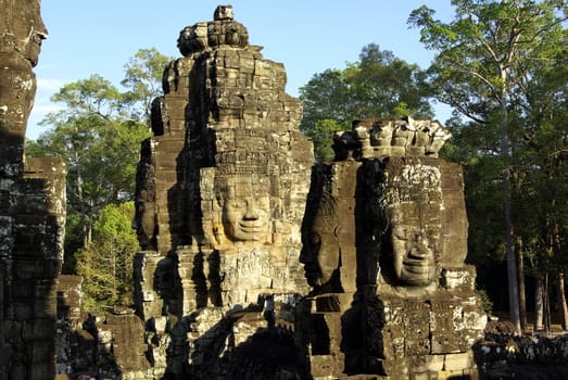 Many stone faces on several towers of Bayon Temple in Angkor