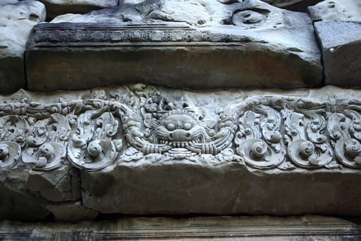 It's a close-up of an engraved grey stone of a temple in Angkor