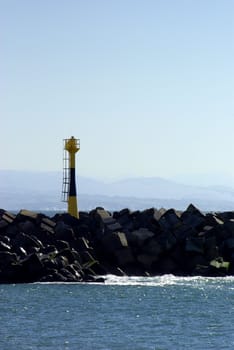 View of the beacon of a jetty in the foreground on mountain landscape