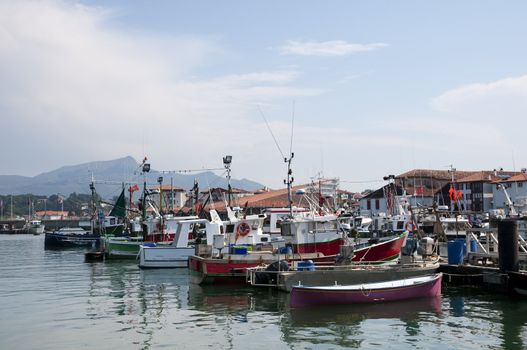 Boats parking in a little harbor with sky and moutains in background