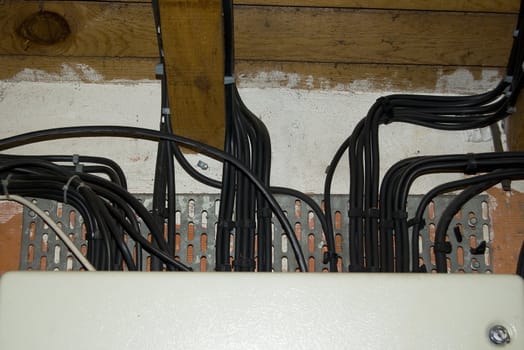 Start of some black electrical cables on an old wall