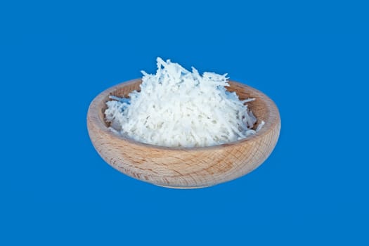 Wooden bowl full of coconut meal isolated on blue