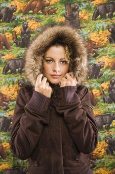 Caucasian young adult woman wearing coat with fur hood looking at viewer.