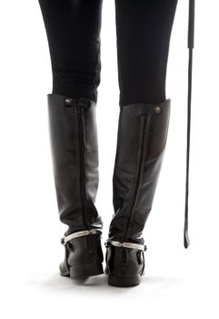 beautiful legs in black leather horseman boots with riding-crop over white