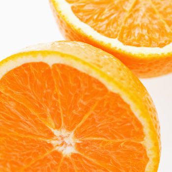 Close up of halved orange against white background.