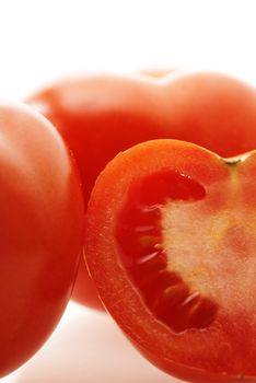 close up shot of ripe juicy tomatoes over white. Focus on pulp