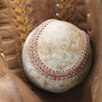 Close up of baseball resting in baseball glove.