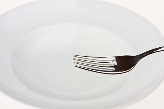 fork on a white plate isolated