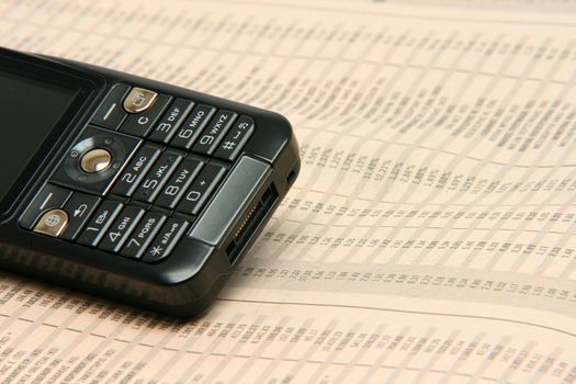 black cellphone detail on financial newspaper business concepts