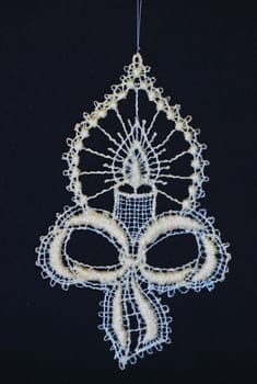 crocheted decoration showing a candle and a bow