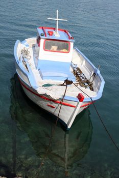 colorful traditional greek small wooden fishing boat moored