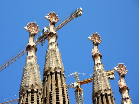 Towers and cranes of the Sagrada familia church by beautiful weather, Barcelona, Spain