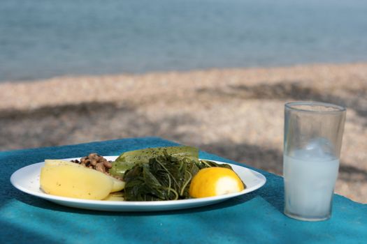 boiled mixed vegetables salad with glass of ouzo