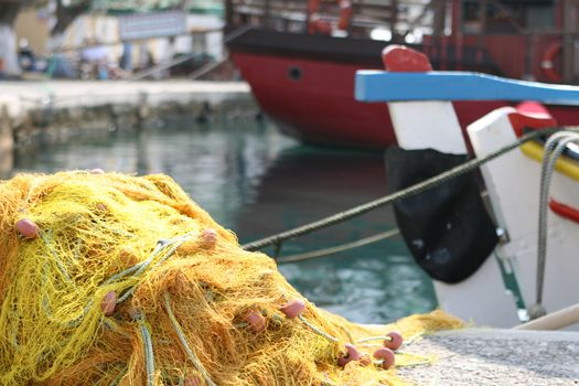 detail from  yellow fishingnet and boats background blur