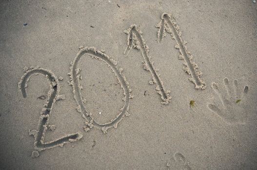 Year 2011 written in sand.
