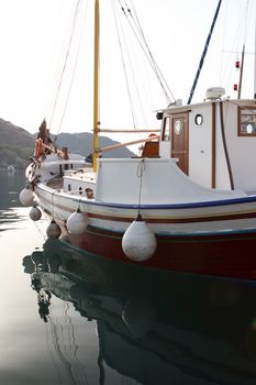 detail from traditional wooden sail boat reflected on water patmos greece