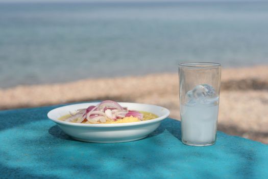 greek traditional food fava with glass of ouzo by the sea