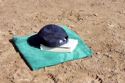 detail blue baseball hat on green towel  and book