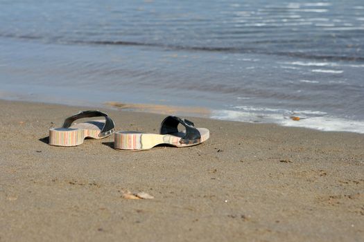 closeup couple of woman sea slippers on the beach with copy space