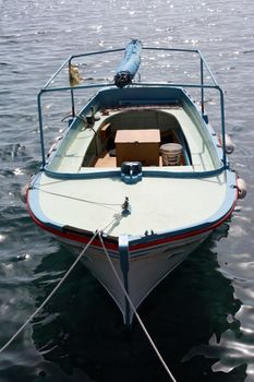 small wooden fishing boat anchored 