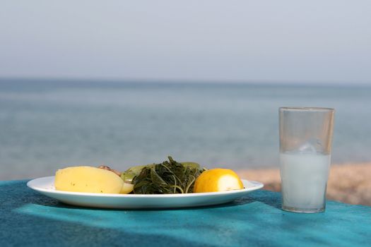 sea sky and food boiled mixed vegetables salad with glass of ouzo greece