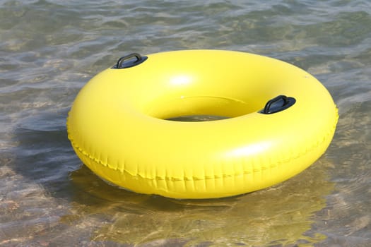 large yellow Inflatable Swimming Ring floating in the sea