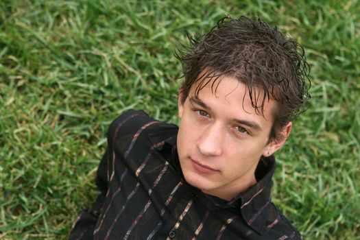 young man seating on grass looking front