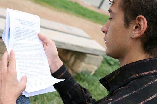 profile of young student reading outdoors