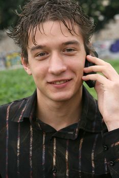 young man talking with cell phone outdoors smiling