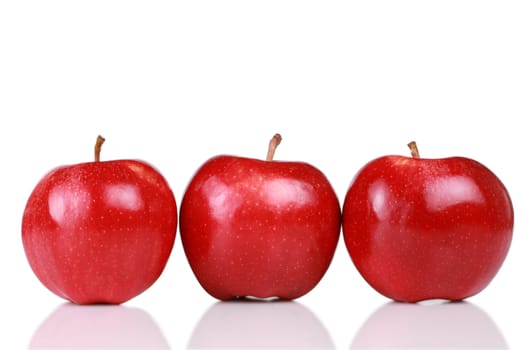 Three shiny red apples in a row isolated on white