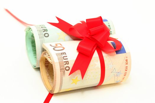 rolled euro banknotes fifty and hundred with red ribbon