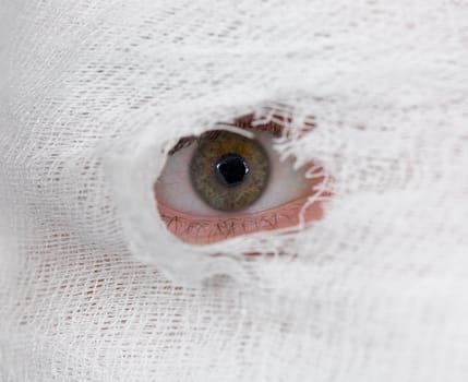 Male eye looking on hole in bandage