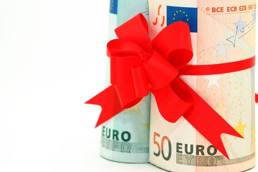 closeup rolled euro banknotes fifty and hundred with red ribbon