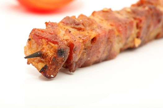 macro pork kebap on wooden stick grilled isolated tomato blur background