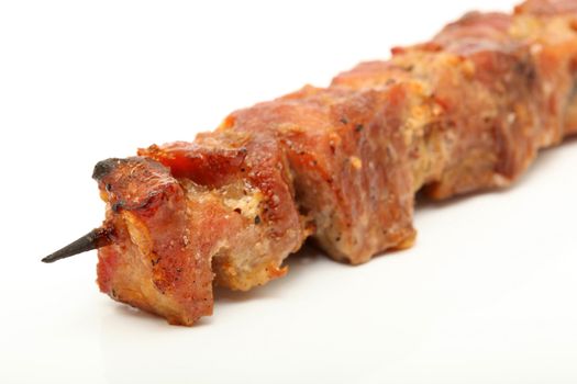 closeup pork kebap on wooden stick grilled isolated on white background