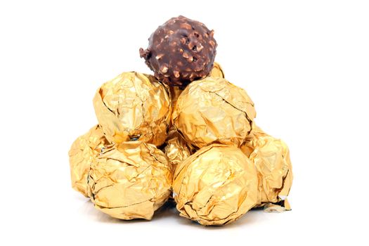 gold wraped chocolate balls pyramid isolated on white background