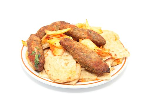 kebab plate with fried potatos and four stakes isolated on white background
