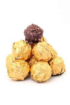 gold wraped chocolate balls pyramid isolated on white background with copyspace