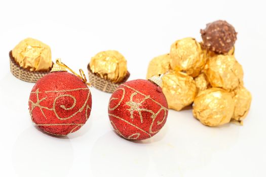 xmas balls and gold wraped chocolates isolated on white background