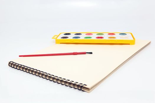 spiral painting block with brush and watercolor palette