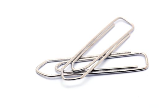 two metallic paper clips isolated on white background