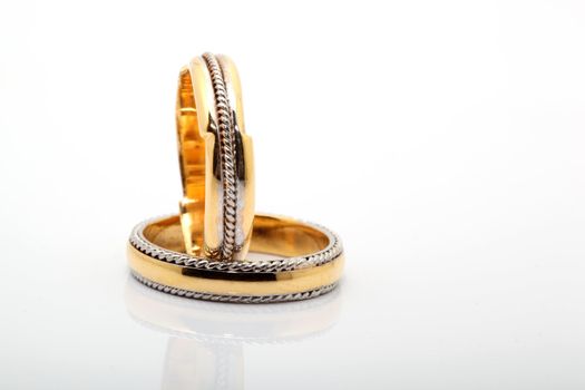 two wedding rings on white background with reflection