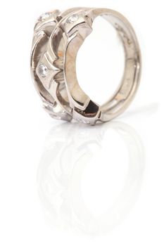 vertical closeup white gold ring with gem stones isolated and reflected