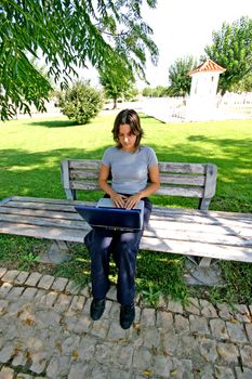 woman working on a laptop on a park